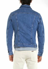 Giacca in denim di blu medio, con colletto classico, yoke sul retro e tasche laterali, dalla forma aderente e con dettagli di cucitura sottile.