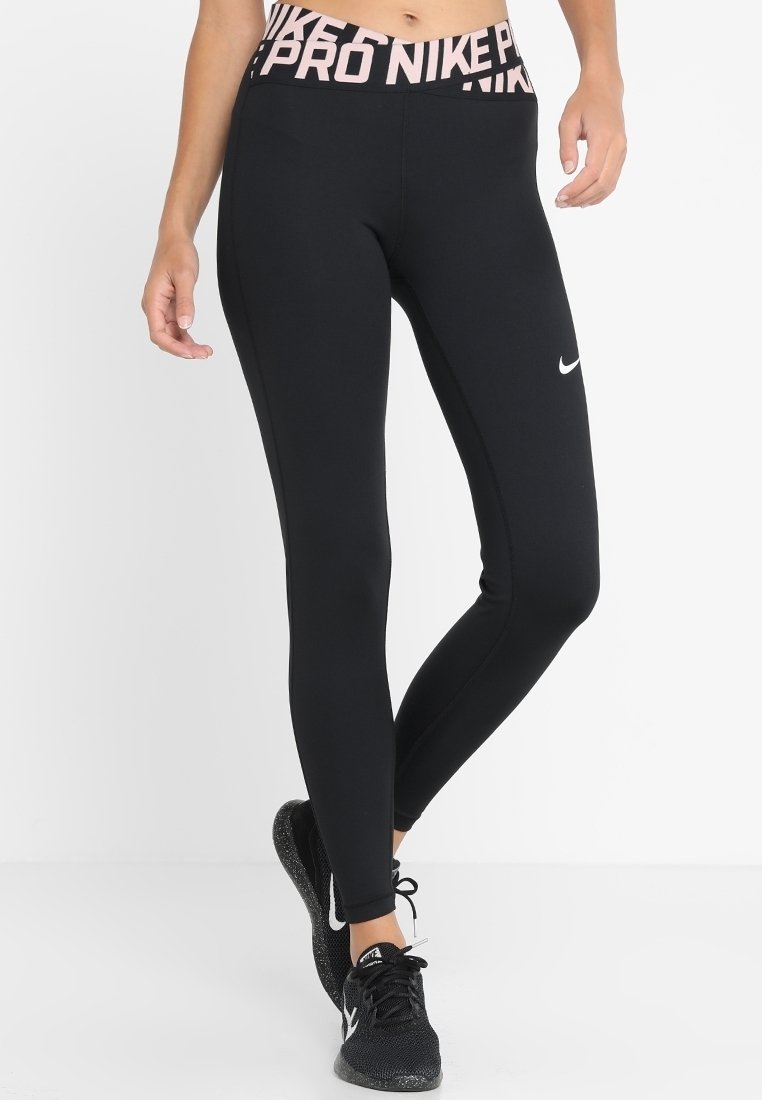Leggings de sport noirs avec une taille haute, ornés du texte rose "PRO NIKE", fabriqués dans un tissu extensible, conçus pour le confort et la mobilité.