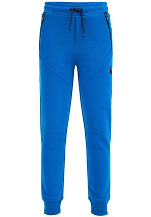 Pantalon de survêtement bleu fuselé avec cordon de serrage noir, bords côtes aux chevilles, poches latérales zippées et une petite étiquette de logo noire sur la cuisse droite.