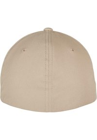Beige baseballpet van een gladde, textuurrijke stof. Heeft een ronde kroon, een kleine knop bovenop en gestikte details langs de naden.