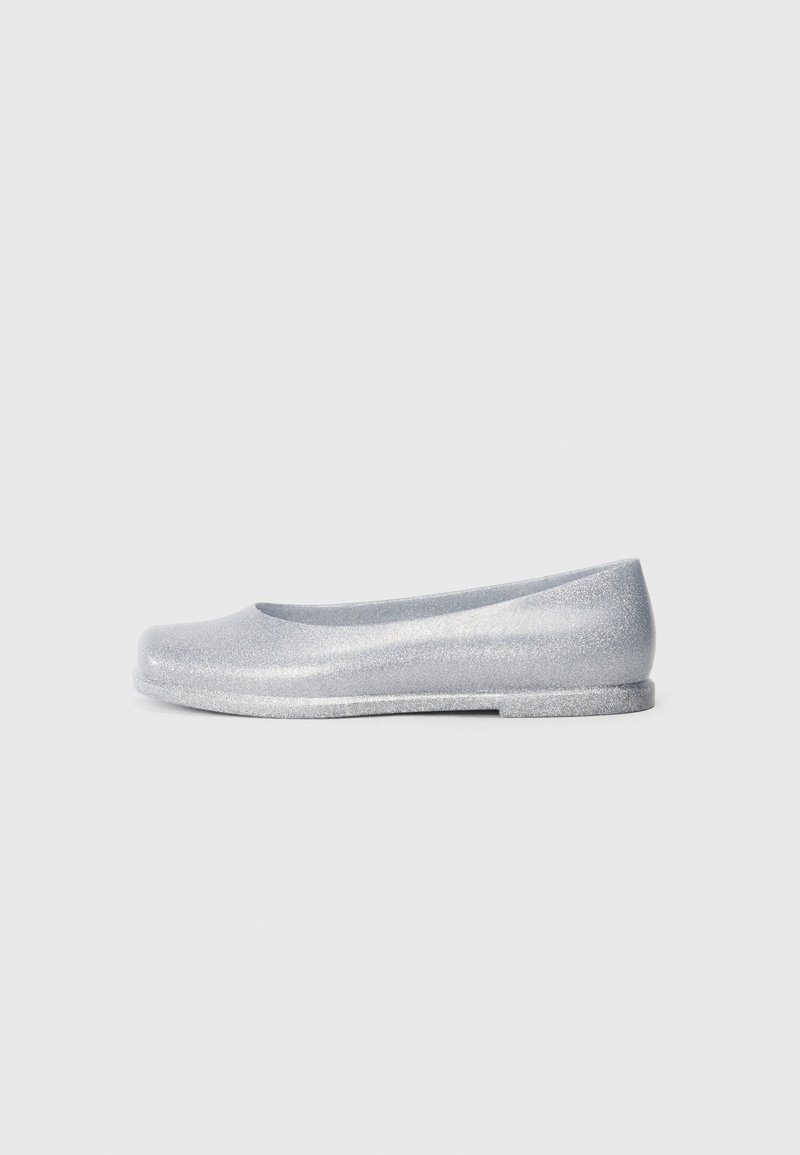 Ballerines argentées à paillettes avec un bout arrondi, texture lisse, profil bas et talon minimal. Design simple sans embellissements supplémentaires.