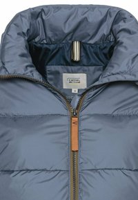Blauwe gewatteerde jas met een hoge kraag, ritsluiting en oranje ritslip. Interne voering in een contrasterende donkere kleur; label zichtbaar.