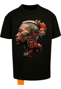 Svart t-skjorte med grafisk design av en profil med blomsterdetaljer, levende farger og store sirkulære øredobber. Inkluderer en oransje merkelapp.