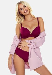 Bordeaux gewatteerde beha met verstelbare bandjes en bijpassende high-waisted slipjes, gecombineerd met een lichtroze oversized shirt. Soepele textuur.