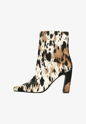 Pointed-toe ankle boot in patterned black, brown, and white faux fur. Chunky heel and smooth black accent at the base.