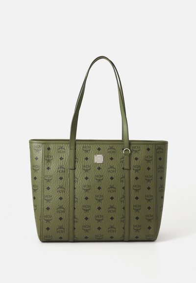 Green leather tote bag with black MCM logos and symbols, dual handles, and a small silver brand plaque on front center.