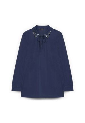 Blusa azul marino de manga larga con cuello con solapa adornado con tachuelas metálicas, cierre con lazo en el cuello y puños de manga plisados.