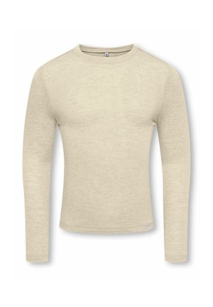 Chemise beige cintrée à manches longues et col rond, avec une texture subtile et une petite étiquette en tissu près de l'ourlet inférieur sur fond blanc.