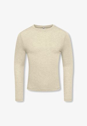 Chemise beige cintrée à manches longues et col rond, avec une texture subtile et une petite étiquette en tissu près de l'ourlet inférieur sur fond blanc.