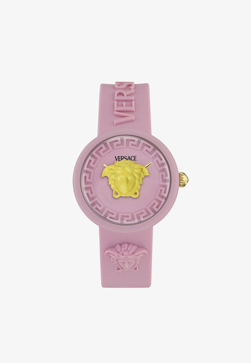 Rozā gumijas pulkstenis ar apaļu seju, uz kuras attēlota dzeltena Medūzas dizaina, zelta rādītājiem un Grieķu atslēgas ornamentiem, ar "VERSACE" zīmolu.