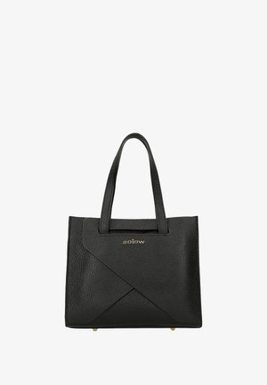 Sac à main en cuir noir avec surface texturée, motif géométrique à l'avant, doubles poignées courtes et accent logo doré. Dimensions non spécifiées.