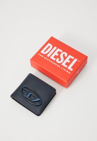 Navy leather wallet with a blue logo accent, presented next to a red box with "DIESEL FOR SUCCESSFUL LIVING" in white text.