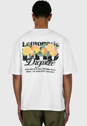 Witte katoenen t-shirt met een graphic van sinaasappels en tekst op de achterkant. Het ontwerp bevat groene bladeren en een verouderd lettertype.