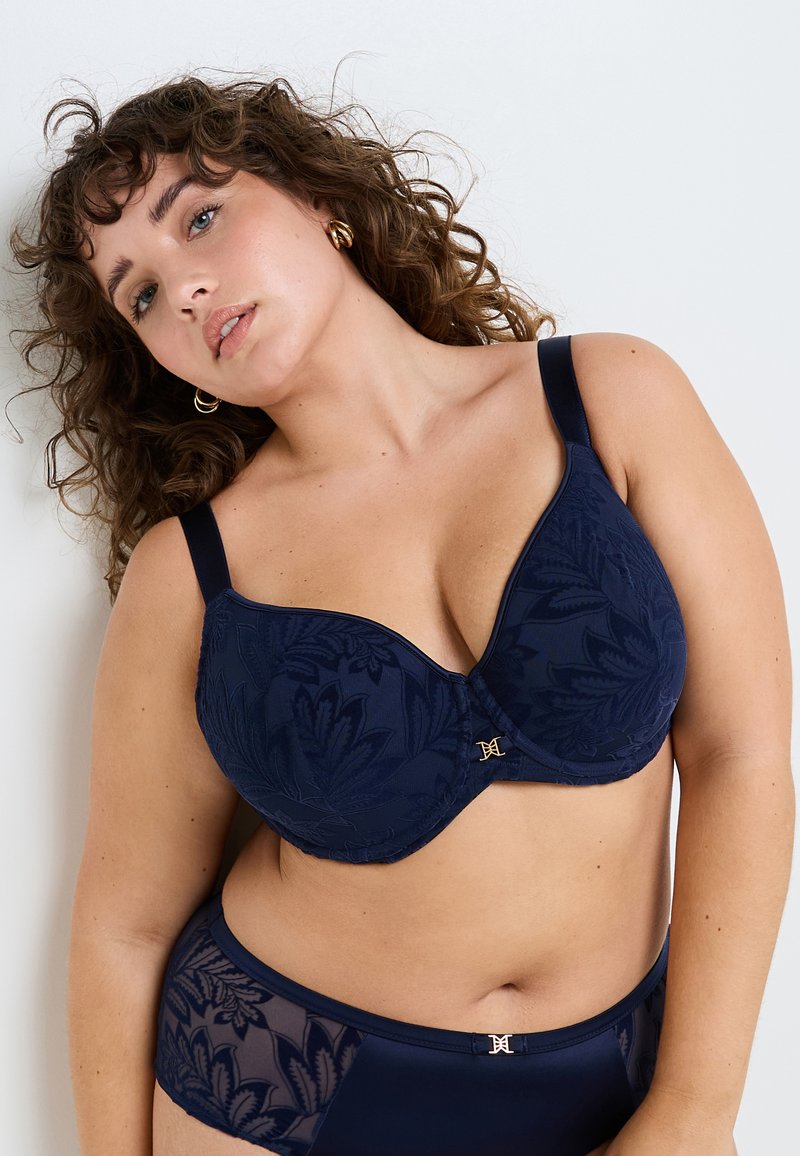 Set di reggiseno e slip abbinato in blu navy, caratterizzato da motivi in pizzo floreale, tessuto morbido, modellatura con ferretti e dettagli in metallo dorato.