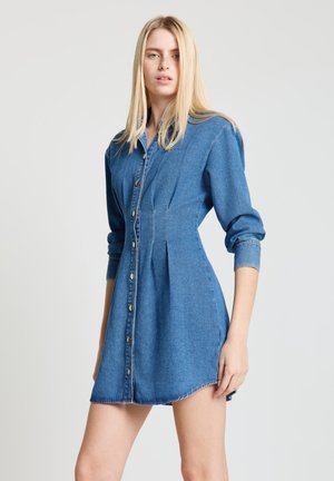 Jeanskleid in mittlerem Blau mit langen Ärmeln, durchgehender Knopfleiste und leicht geschwungenem Saum. Verfügt über dezente Falten und Nähte.