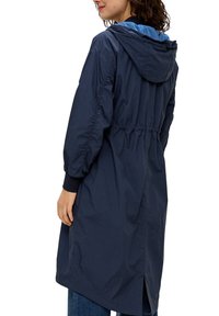 Granatowa, lekka kurtka z kapturem, elastycznym pasem, marszczonymi rękawami i wentylacją z tyłu. Gładki, wodoodporny materiał.