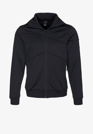 Zwarte jas met ritssluiting en hoge kraag, gestructureerde stof, schuine naden voor het design en zijzakken. Eenvoudige en moderne atletische stijl.