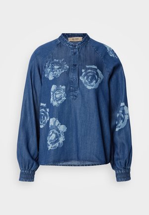 Chemise en denim bleu foncé avec une coupe décontractée. Présente des imprimés floraux en bleu clair, un plastron à boutons et des poignets élastiqués pour un effet froncé.