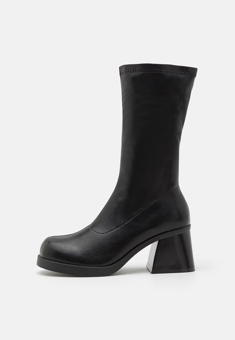 Botte noire en cuir mi-mollet avec bout arrondi, talon bloc épais et dessus lisse avec détail de bord supérieur cousu.