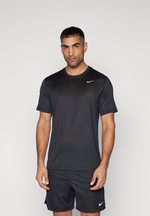 Sort atletisk t-shirt med korte ærmer og rund halsudskæring. Nike-logoen pryder venstre bryst. Lavet af et glat, let materiale.