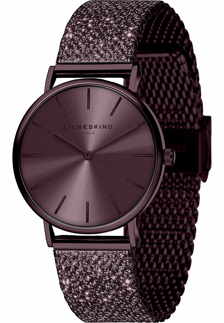 Lila metallklocka med ett strukturerat, glittrande meshnätband. Rund urtavla med en minimalistisk design och smala timmarkörer samt logotyp.