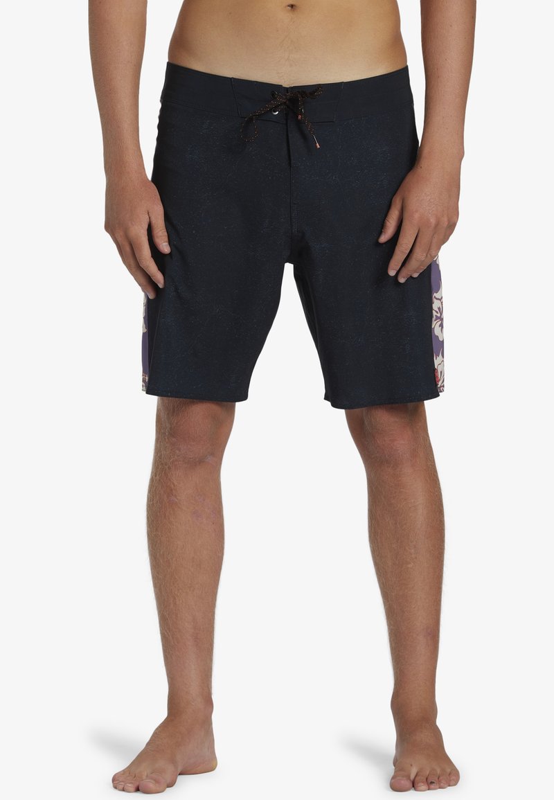 Bañador negro con acentos florales en púrpura y crema en los laterales. Cuenta con una cintura ajustable y un acabado texturizado.