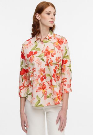 Floral blouse featuring a light background with red and green botanical patterns, button-front closure, and three-quarter sleeves.