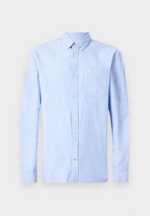 Chemise bleu clair à manches longues, en tissu doux, dotée d'un col boutonné et d'une poche poitrine unique.
