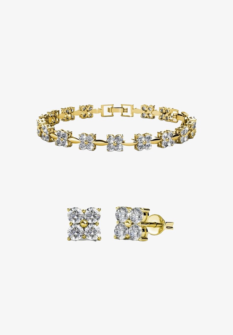 Ensemble de bracelet en or et boucles d'oreilles pendantes, chacun présentant des clusters en forme de fleur composés de quatre diamants scintillants.