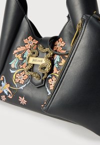 Μαύρη δερμάτινη τσάντα χειρός με πολύχρωμη κεντητή λουλουδάτη διακόσμηση, χρυσό κούμπωμα σε σχήμα φιδιού και ορατή χρυσή λεπτομέρεια φερμουάρ.
