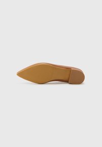 Chaussure à bout pointu marron avec un dessus en cuir lisse, semelle plate et petit talon. Caractérisée par une semelle en caoutchouc texturé pour une meilleure adhérence.