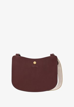 Dunkelrote Leder-Umhängetasche mit gewölbtem Deckel, goldener Druckknopf-Verschluss, geprägtem Logo und beigem Stoffriemen.