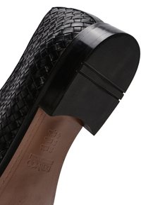 Chaussure plateforme en cuir tissé noir avec une semelle en caoutchouc noir solide. Talon épais notable et surface texturée sur le matériau supérieur.