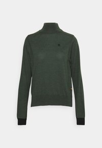 Zielony sweter z wysokim kołnierzem, wykonany z miękkiego materiału. Posiada długie rękawy oraz czarny akcent logo na klatce piersiowej. Ribbed wykończenia rękawów i dołu.