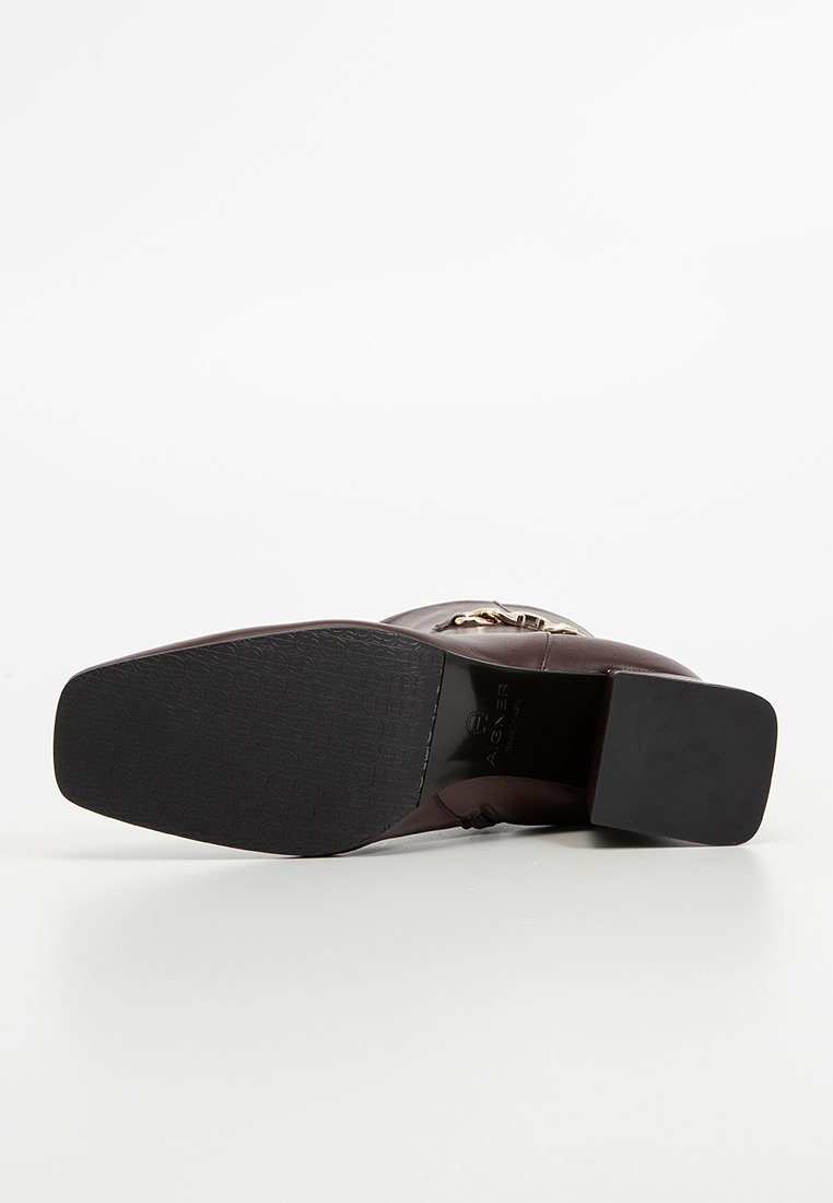 Burgundowe skórzane botki za kostkę z złotymi elementami i kwadratowym czarnym obcasem, z teksturowaną podeszwą i minimalistycznym designem.