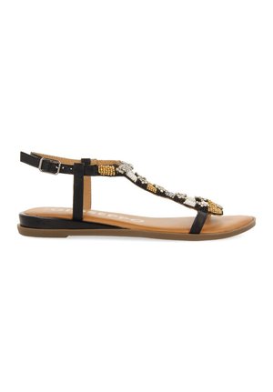 Las sandalias negras planas presentan un diseño tipo tira con adornos de cuentas en dorado, blanco y negro. Una correa con hebilla en el tobillo proporciona un ajuste seguro.