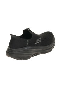 Schwarzer, ohne Schnürsenkel gestalteter Sportschuh mit einer strukturierten Mesh-Oberfläche, gepolsteter Sohle und minimalem Branding. Verfügt über eine glatte Oberfläche und zusätzliche Fers Unterstützung.