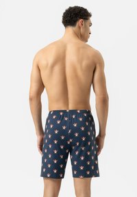 Marineblauwe zwemboxers met een bloemenpatroon, een elastische tailleband en een knielange snit. Gemaakt van lichtgewicht, ademend materiaal.