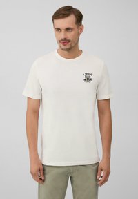 Weißes T-Shirt mit kurzen Ärmeln aus Baumwolle, versehen mit einem schwarzen gestickten Design auf der linken Brust und einem Rundhalsausschnitt. Lässige Passform.