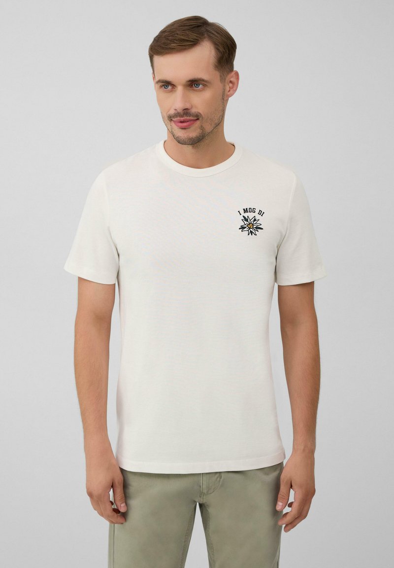 Weißes T-Shirt mit kurzen Ärmeln aus Baumwolle, versehen mit einem schwarzen gestickten Design auf der linken Brust und einem Rundhalsausschnitt. Lässige Passform.