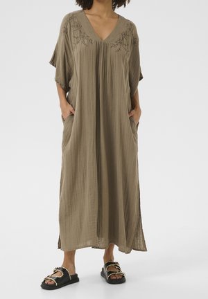 Olivengrünes Maxikleid mit V-Ausschnitt, lockerer Passform, kurzen Ärmeln, Falten und bestickten Details an der Brust. Mit seitlichen Taschen.