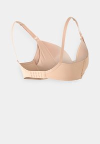 Nude-colored bra with padded cups, adjustable straps, and a hook-and-eye closure. Smooth fabric with minimal seams for comfort.