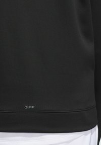 Black sweatshirt with smooth texture, featuring a subtle "COLD.RDY" label at the hem. White undershirt is partially visible beneath.