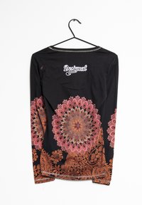 Svart långärmad skjorta med intrikata orange och rosa blommönster på ärmarna, ribbad krage och broderad logotyp på baksidan.