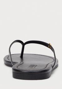 Črne japonke z gladkim podplatom, tankim trakom in zlatimi dodatki na stičišču trakov.