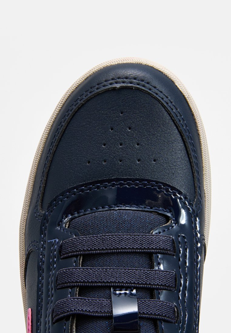 Marineblaue Sneakers mit einem glatten Leder-Obermaterial, strukturiertem Stoffzunge, flachen Schnürsenkeln und einer beigen Gummisohle. Kleine Perforationen an der Zehe.