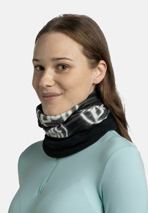 Bufanda multifuncional de patrones en blanco y negro con una textura suave, superpuesta sobre una base oscura, combinada con una camiseta de manga larga azul claro.