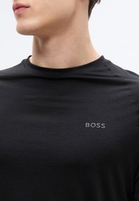 Μαύρο T-shirt από λείο ύφασμα, με λαιμόκοψη crew και διακριτικό λογότυπο BOSS στο στήθος σε ελαφρώς ανάγλυφο, αντιθετικό τόνο.