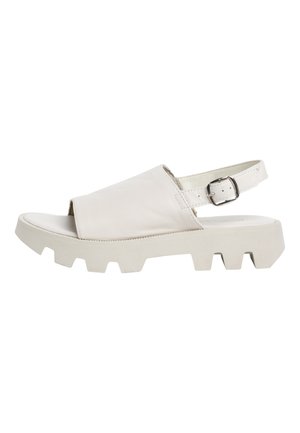 White leather sandal with a wide front strap, open toe, adjustable ankle strap, and chunky white rubber outsole with a textured pattern.