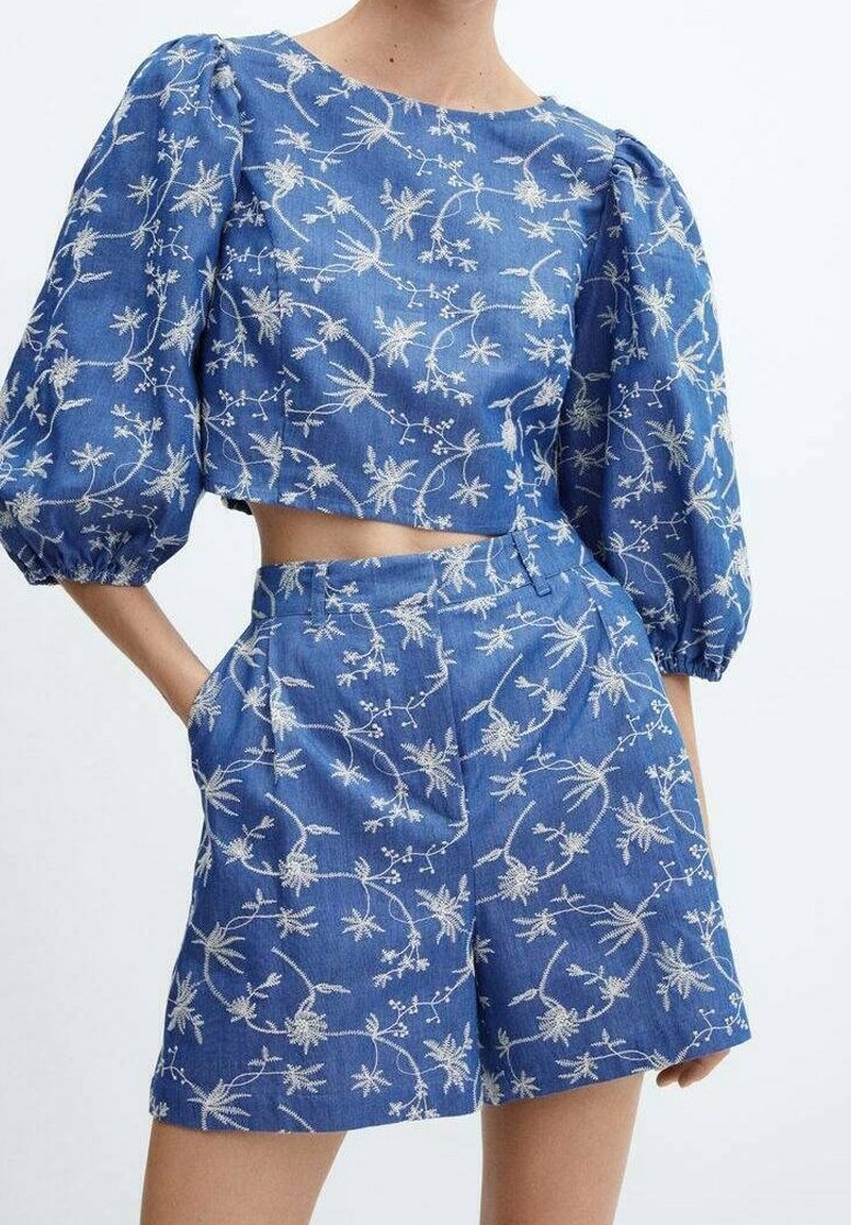 Ensemble deux pièces bleu avec broderie florale blanche, composé d'un haut court à manches bouffantes et d'un short taille haute avec poches latérales.